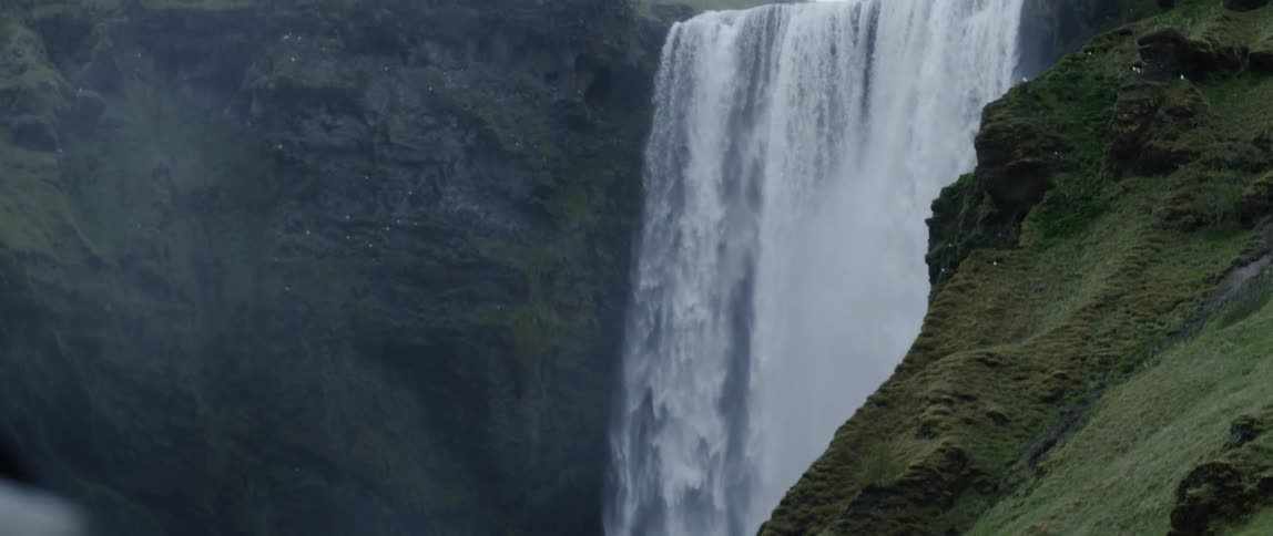 A waterfall flows over a cliff