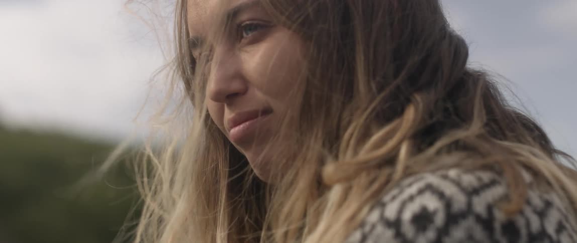 Wind blows the hair around a woman's face