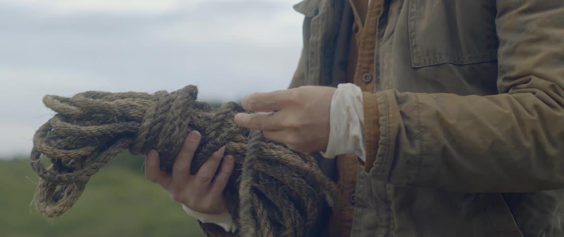 A man holds a rope in his hands