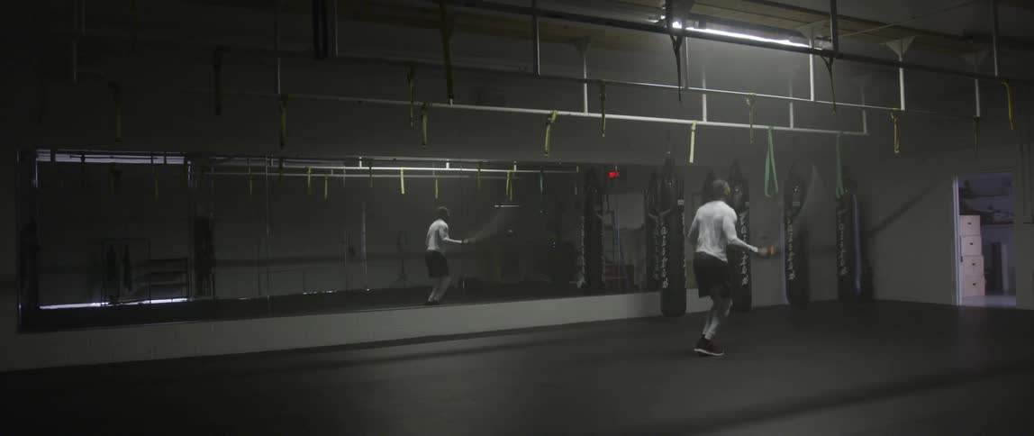 A man is jumping rope in a gym
