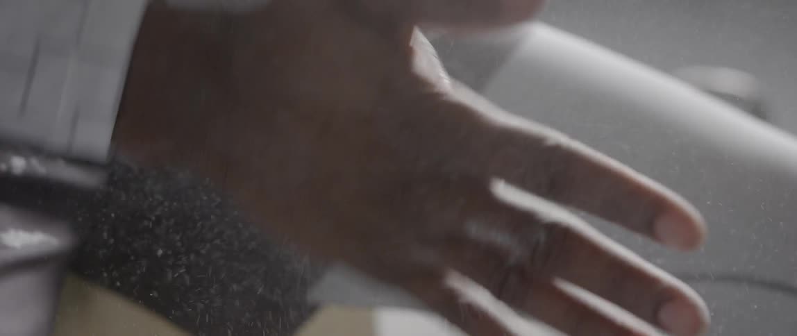 A man rubs his hands together with dust