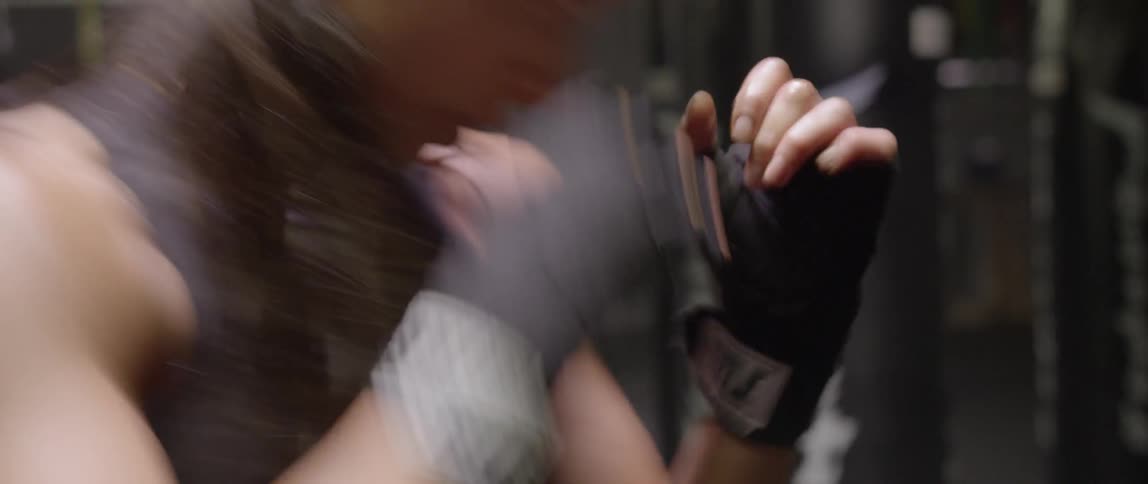 A woman is boxing in a gym