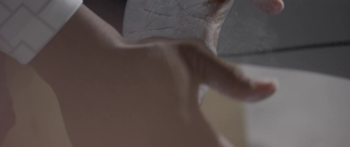 A person rubbing white powder onto the palms of their hands