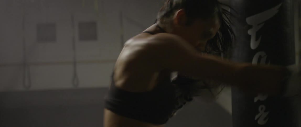 A female boxer is hitting a punching bag