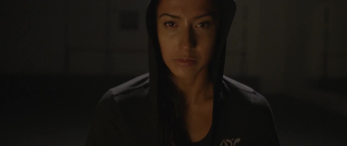A woman wearing a hood looks up