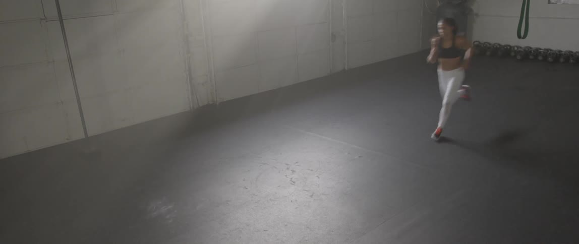 A woman sprints across a gym floor