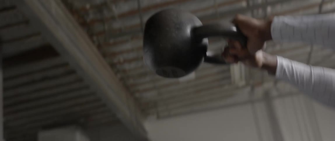 An athlete uses a kettlebell to work out