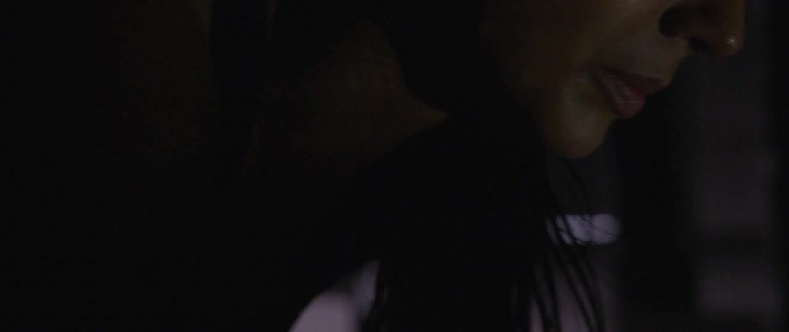 Woman in dim room sweating and looking exhausted