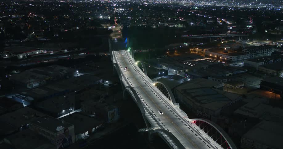 Cars drive across the sixth street bridge at night