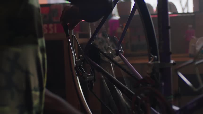A man is working on a bike wheel