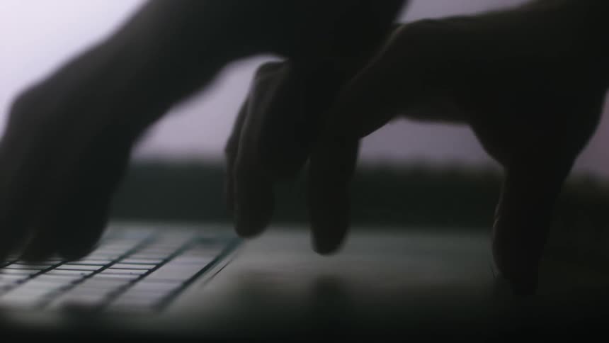 A person is typing on their laptop