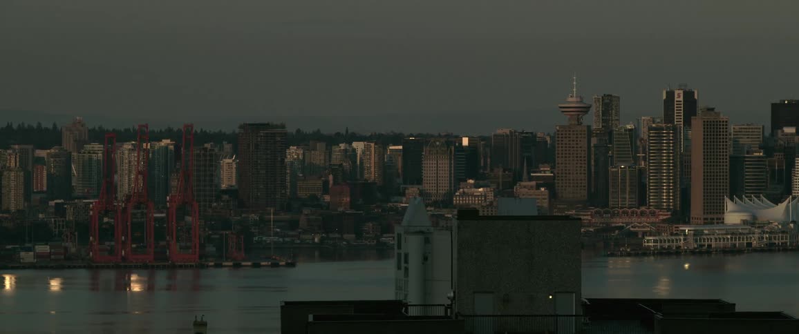 An aerial view shows a city with several buildings against an almost black night sky