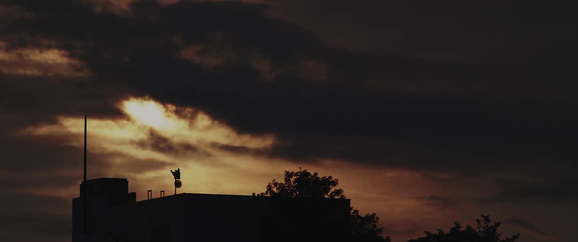 Sunlight shines through an opening in a layer of thick dark clouds