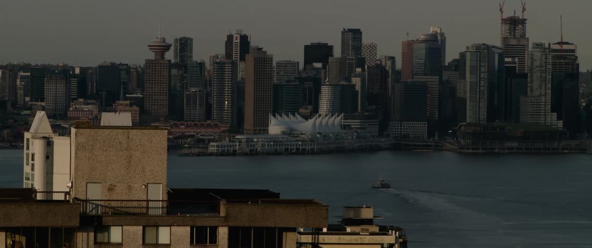 A speedboat moves through the ocean past downtown