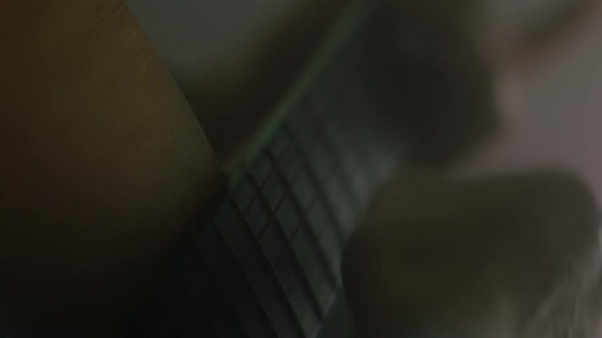 A closeup shot of a persons hands strumming guitar strings