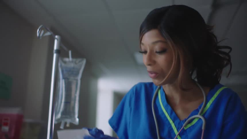 Doctor talks to nurse as the nurse opens package near iv