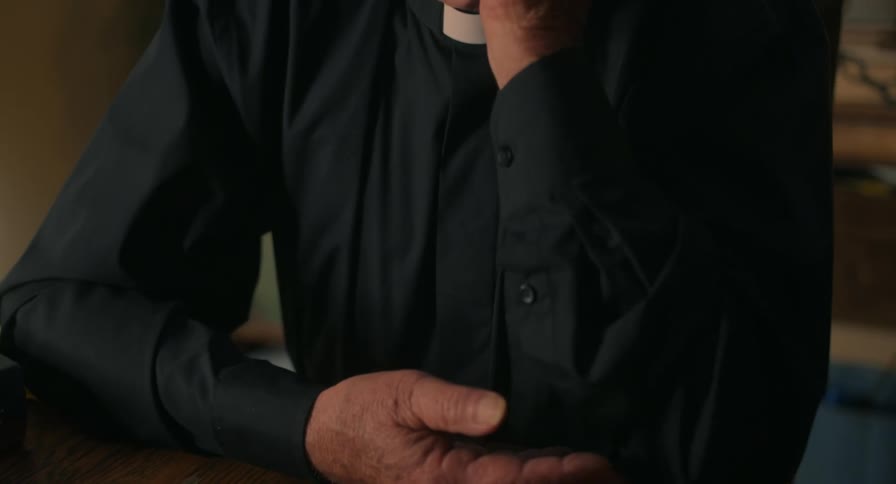 A priest looking at a book in a room
