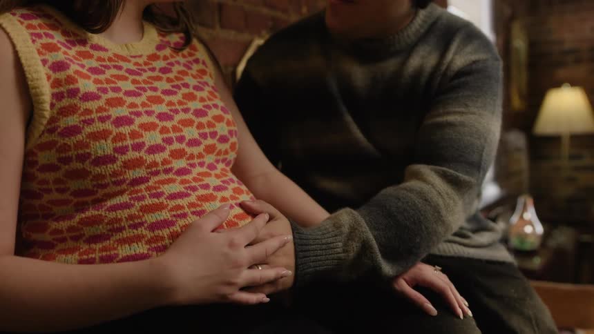 A man rubs her pregnant wifes belly