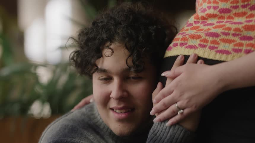 Man joyfully listening to the baby inside the pregnant womans belly