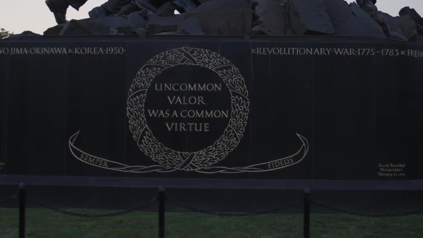 A black monument and half wall with a small fence in front of it