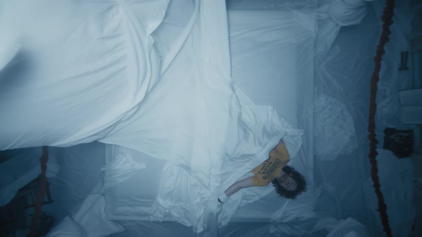 The sheet falls on the man in bed
