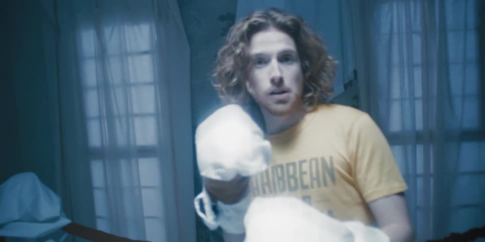 Man with white punching gloves on in a combative stance while being punched in the face