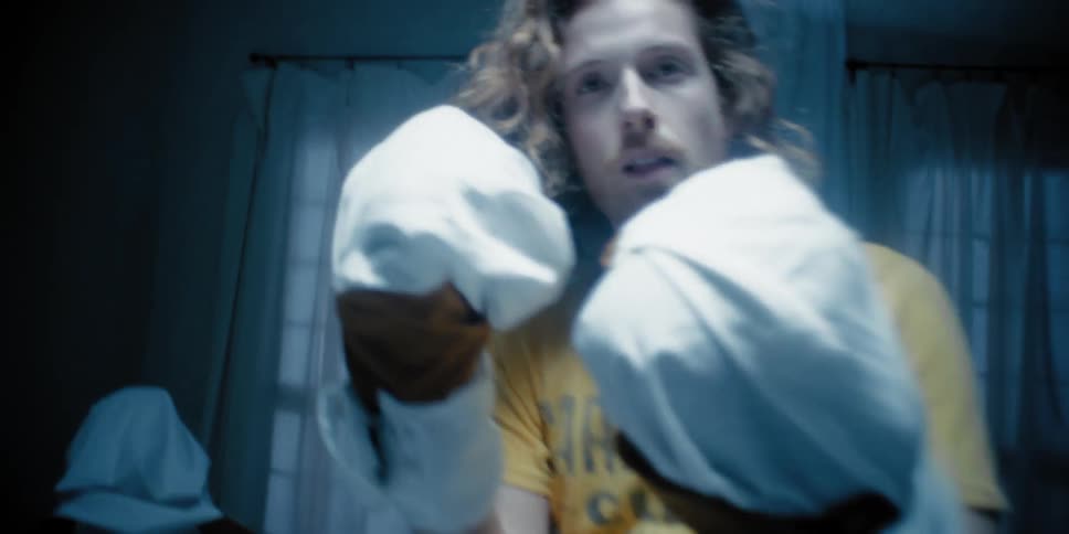 Man wearing boxing gloves in a ring indoors
