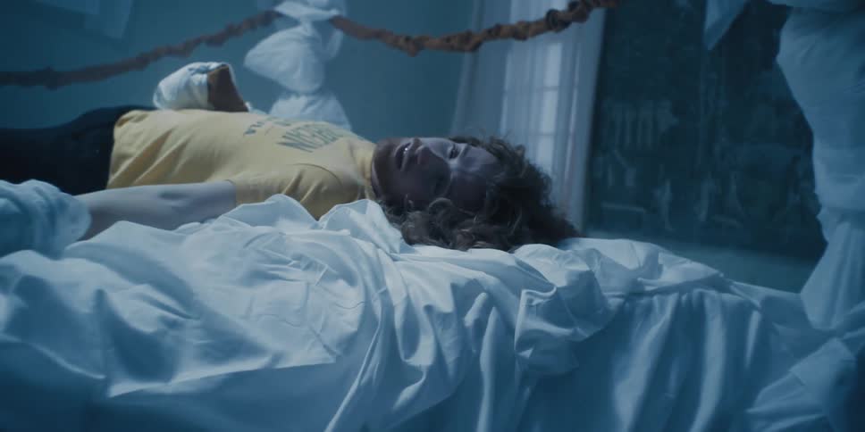 Redheaded performer lies in stylized boxing gym as part of performance art