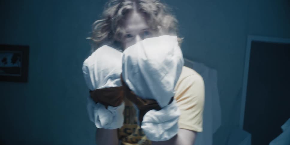Man wearing fabric wrappings on his fists punches in symbolic boxing