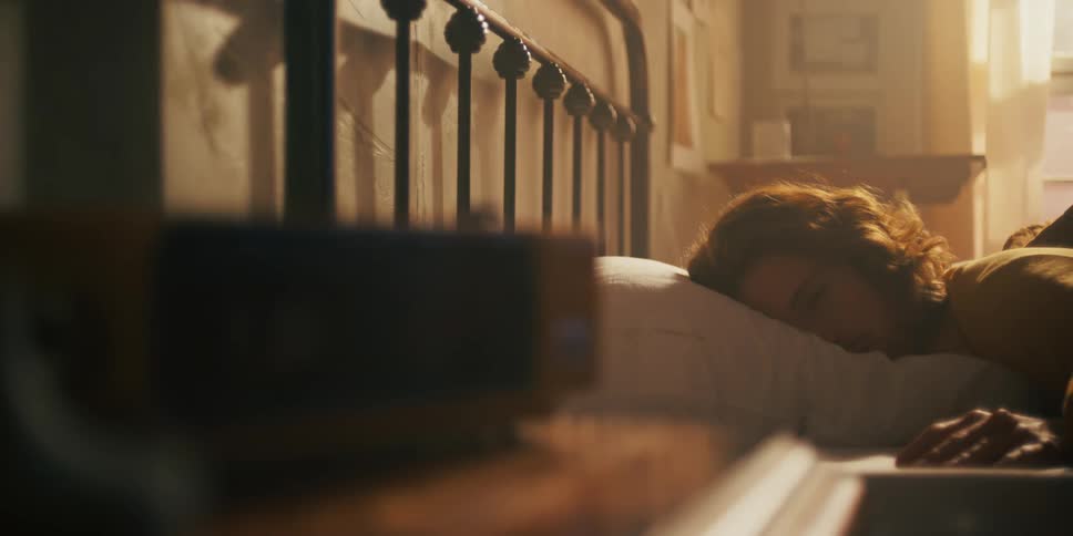 Woman lying in bed wakes up in the morning