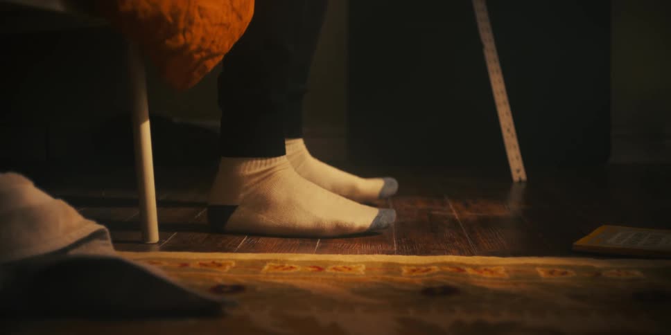 Person getting out of bed flexes their feet on the floor then walks away