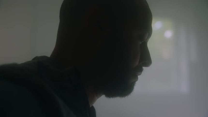 Man sitting indoors with a thoughtful and introspective facial expression