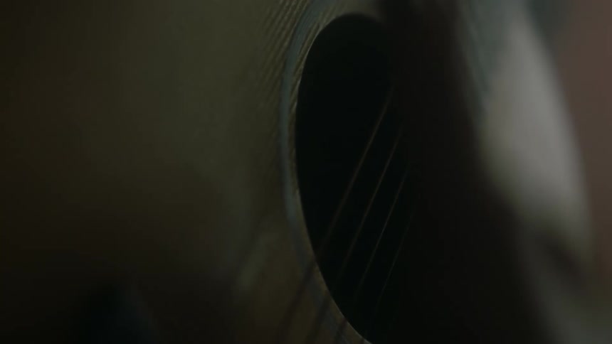 A person plays an acoustic guitar