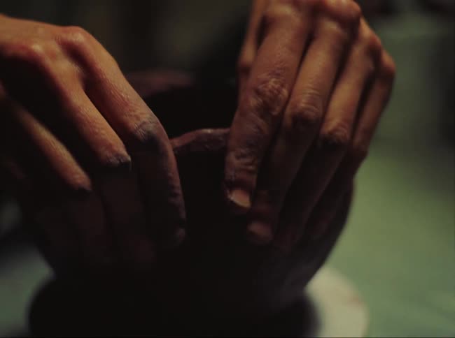 Hands of a potter molding clay