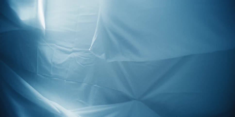 White sheeted mattress and pillows moving back and forth as if to fight the camera