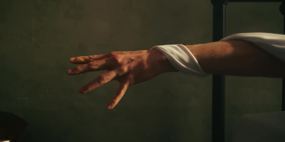 An outstretched arm with a white sheet wrapped around it
