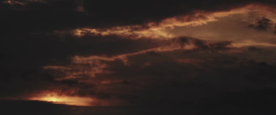 The sun is setting in the horizon of the landscape