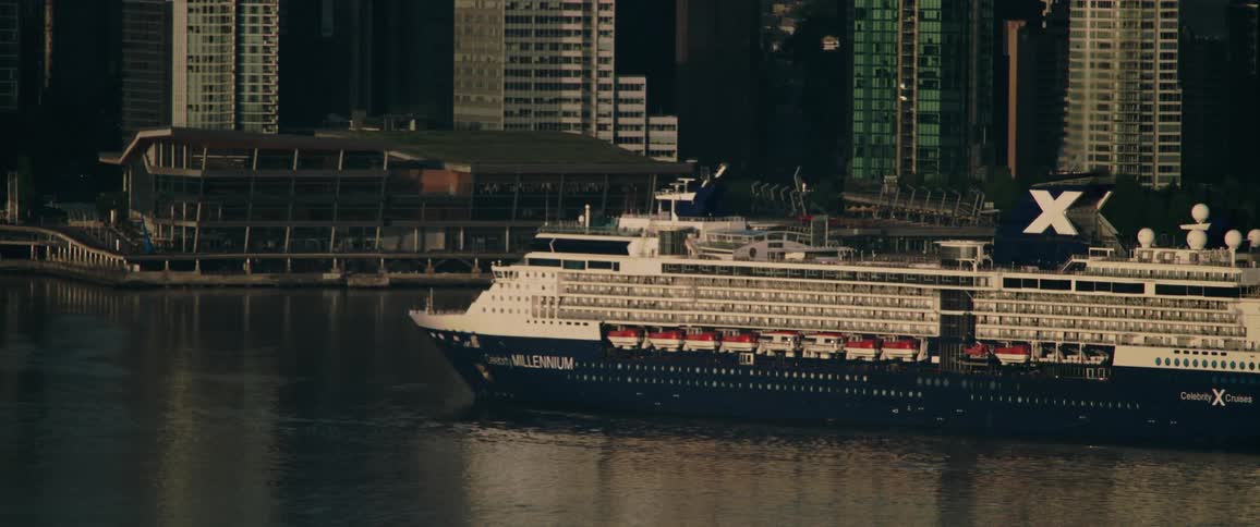 A cruise ship travels along the coast of a metropolis during the day
