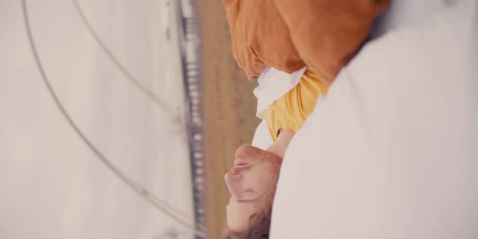 A man sleeps in a bed in an open field