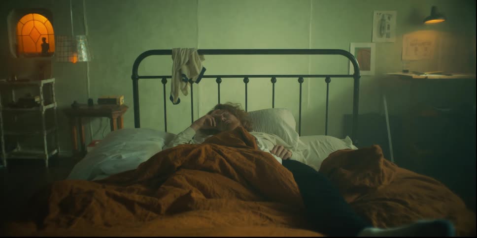 A man sleeps in a bed as it slides toward a wall