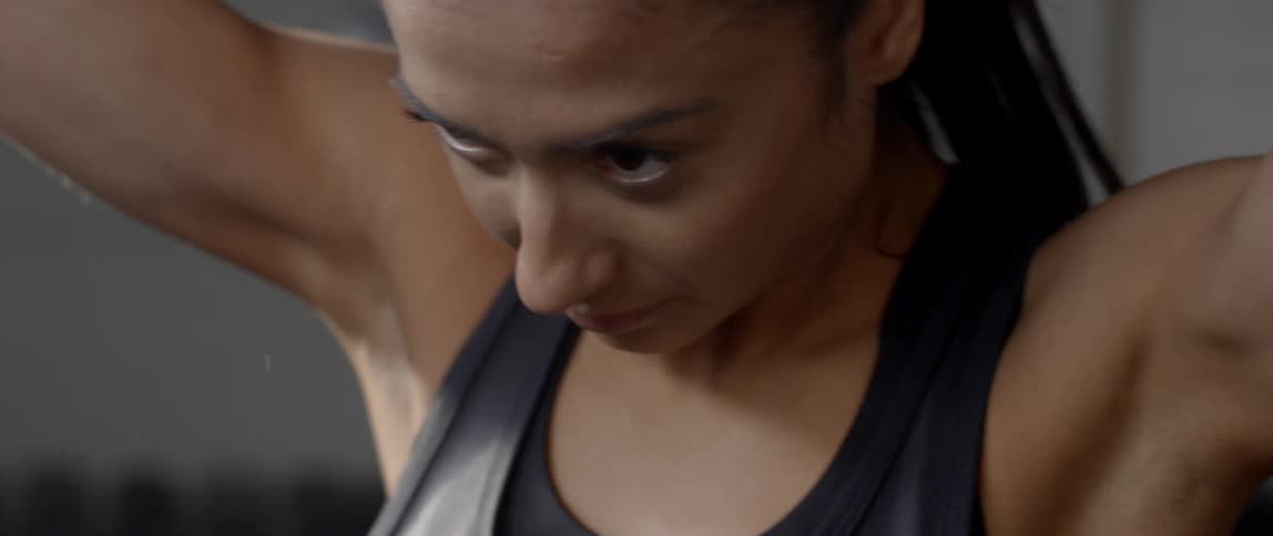 A woman is stretching and tying her hair
