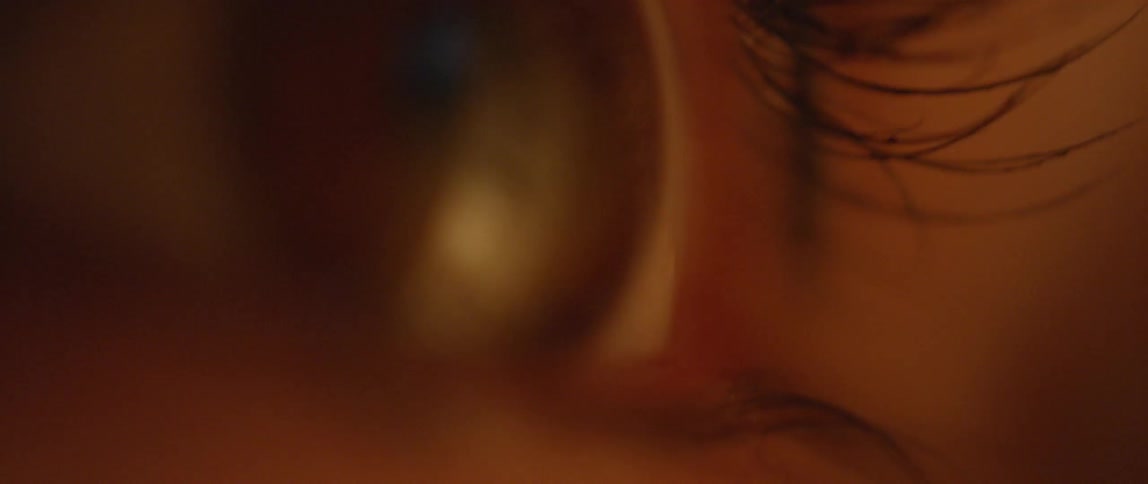 An eye blinks and reflects light