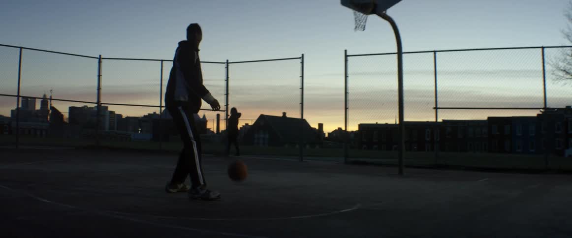Man dribbling basketball before abruptly stopping to look behind him
