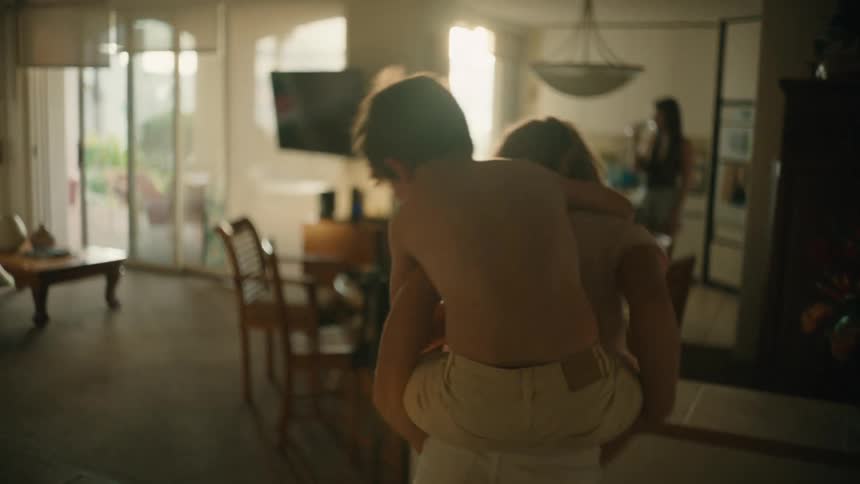 A sister gives her brother a piggy back ride