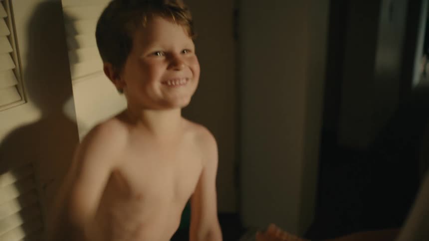 A happy and smiling boy playing rockpaperscissors with someone