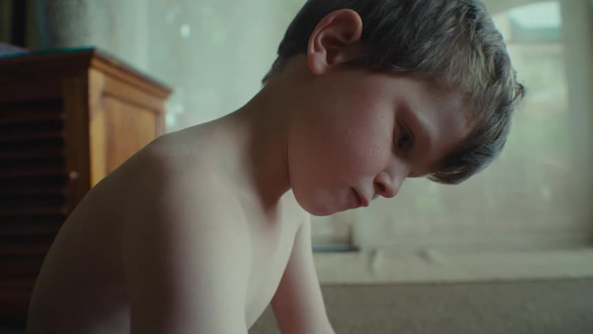 Boy sitting on the floor solving a puzzle with someone