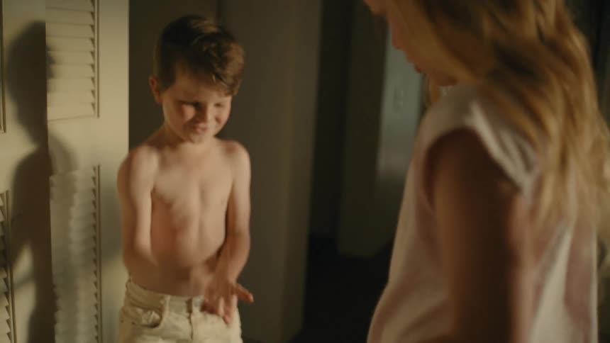 A boy plays paper rock scissors with a girl indoors during the day