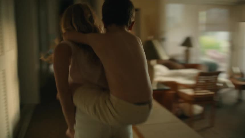 A sister gives her brother a piggyback ride as they run through the house
