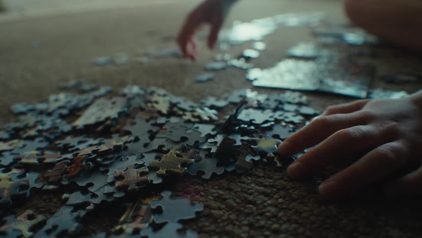 Child solving a puzzle on the carpeted floor