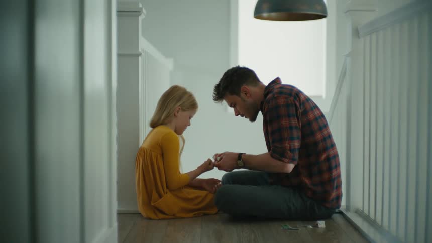 A man bandages his daugthers finger
